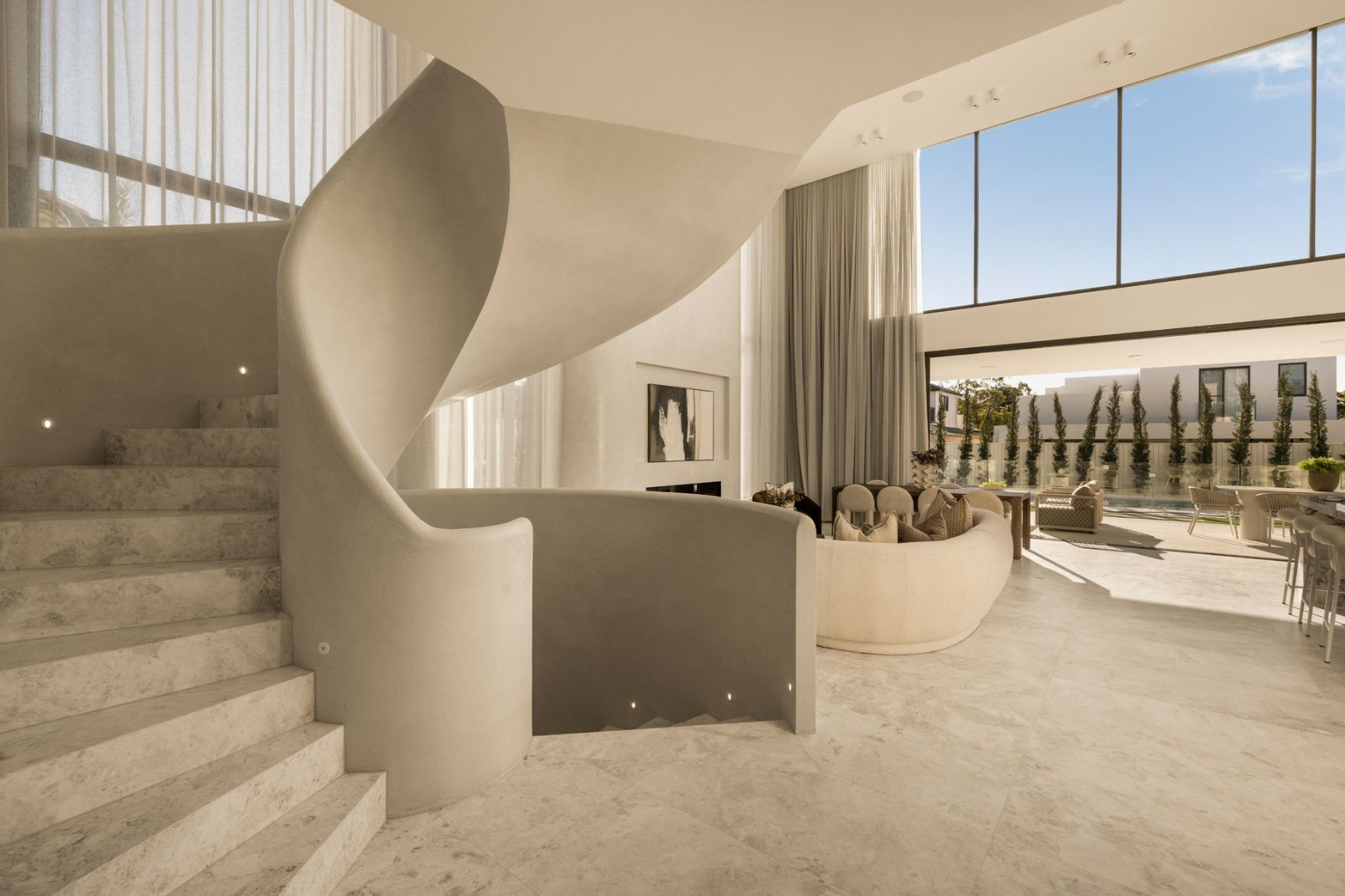 Sculptural plaster staircase in the double-height living volume